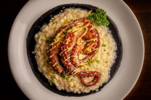 a plate of food with shrimp on risotto at Porto Pacuíba Hotel in Ilhabela