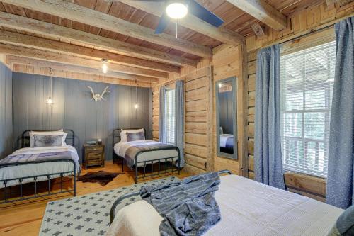 a bedroom with two beds in a log cabin at Peaceful Whitley City Cabin on 10 Wooded Acres! in Whitley City