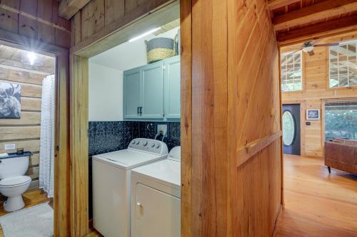 a bathroom with a washer and dryer in a house at Peaceful Whitley City Cabin on 10 Wooded Acres! in Whitley City