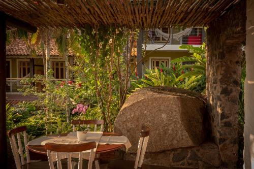 a table and chairs on a patio in a yard at Porto Pacuíba Hotel in Ilhabela