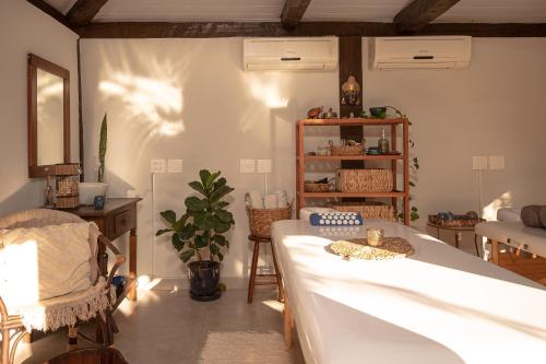 a living room with a large bed and a table at Porto Pacuíba Hotel in Ilhabela
