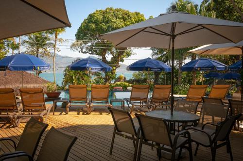 a group of chairs and tables with umbrellas at Porto Pacuíba Hotel in Ilhabela