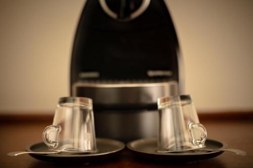 a coffee maker and two glasses on a table at Porto Pacuíba Hotel in Ilhabela