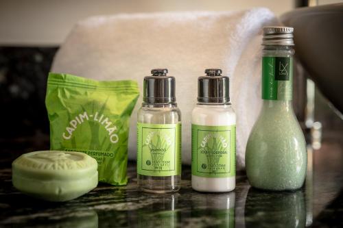 three bottles of soap on a counter with a bag at Porto Pacuíba Hotel in Ilhabela