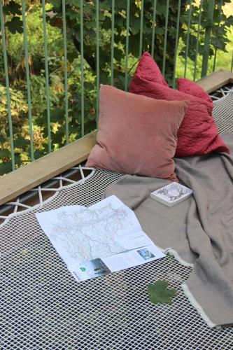 a wicker bed with maps and pillows on it at baumhaus buchengrün in Dobl-Zwaring