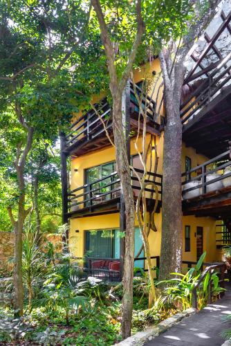 a yellow building with trees in front of it at Terasu Riviera Maya Hotel & Spa, en Xcaret in Playa del Carmen