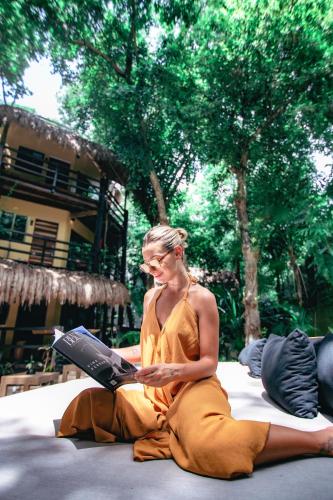 a woman sitting on the ground with a laptop at Terasu Riviera Maya Hotel & Spa, en Xcaret in Playa del Carmen