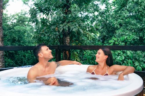 un hombre y una mujer sentados en un jacuzzi en Terasu Riviera Maya Hotel & Spa, en Xcaret en Playa del Carmen