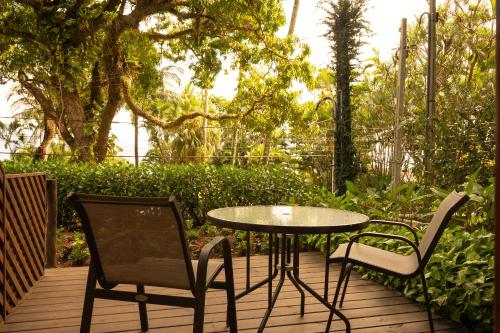 a table and two chairs on a wooden deck at Porto Pacuíba Hotel in Ilhabela