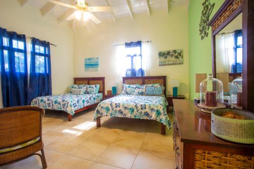 a bedroom with two beds and a table and a desk at Sosua Ocean Village in Sosúa