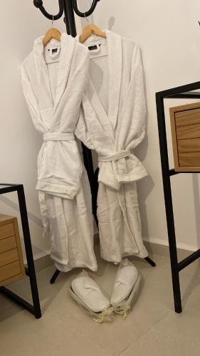 a group of white robes hanging on a wall at מצפור הכנרת- דירת גן לאירוח in Tiberias
