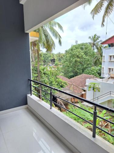 a room with a balcony with a view at Suvarna Grande Homes in Mangalore