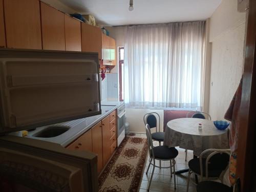 eine Küche mit einem Tisch und einem Waschbecken sowie ein Esszimmer in der Unterkunft Bahçeli Müstakil Daire in Burhaniye