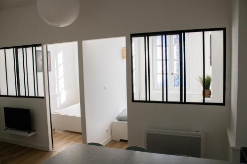 un salon avec une fenêtre et une télévision dans l'établissement La Galerie de Lumière 201, à Aurillac