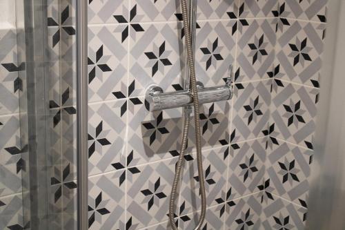 a shower in a bathroom with a tile wall at La Galerie de Lumière 201 in Aurillac