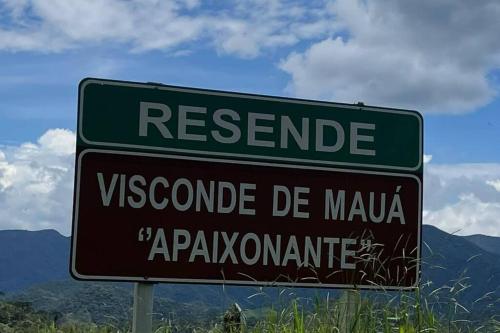 a green street sign on the side of a road at Chalé Floresta Mauá in Resende