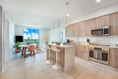 una cocina con armarios de madera y una mesa con sillas. en QUADRO RESIDENCES BY IONICA, en Miami