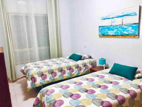 une chambre avec deux lits et une fenêtre dans l'établissement Casa playa Las Canteras, à Las Palmas de Gran Canaria