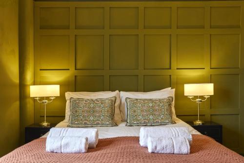 a bedroom with a large bed with two lamps at 81 Promenade Studios in Cheltenham