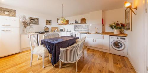 Halistra的住宿－Thomas Telford Lettings - Luxurious Interiors and Seaviews，厨房配有桌椅和洗衣机。