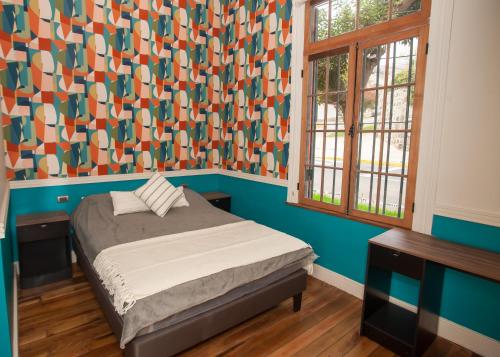 1 dormitorio con 1 cama y una pared colorida en Casa Recreo, en Viña del Mar