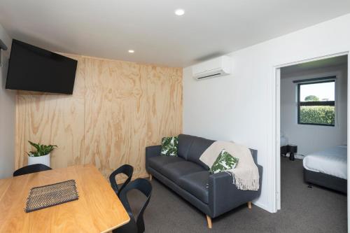 a living room with a couch and a table at Waikanae Beach TOP 10 Holiday Park in Gisborne