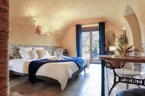 1 dormitorio con 1 cama en una habitación con mesa en Le Mas Lauralie, en Méjannes-lès-Alès