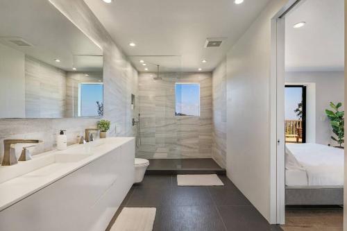 a bathroom with two sinks and a toilet and a shower at Breathtaking Hollywood Hills Vacation Home in Los Angeles