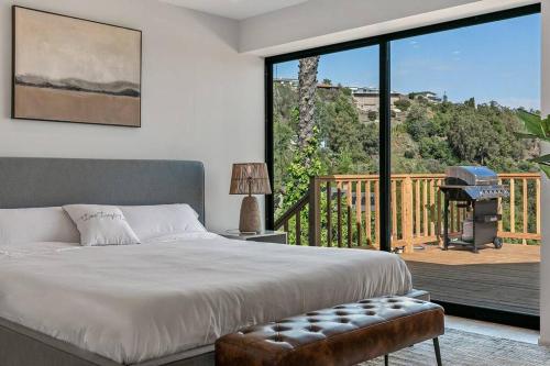 a bedroom with a bed and a balcony with a grill at Breathtaking Hollywood Hills Vacation Home in Los Angeles