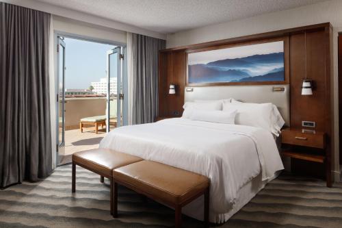 a hotel room with a large bed and a balcony at The Westin Pasadena in Pasadena
