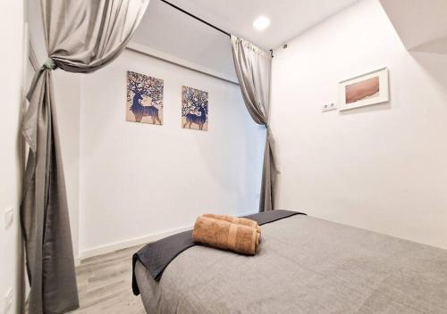 ein Schlafzimmer mit einem Bett in einem weißen Zimmer in der Unterkunft Apartamento Altimiras 'Las Ventas' in Madrid