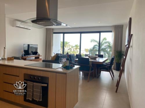 eine Küche und ein Wohnzimmer mit einem Tisch und einem Sofa in der Unterkunft Beautiful Aria Ocean 401 QueridaEstancia in Nuevo Vallarta