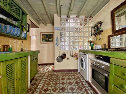 cocina con armarios verdes y lavadora en Cozy Studio en Casa con Encanto, en Caleta de Interián