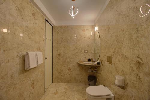 a bathroom with a toilet and a sink at Greenstones Boutique Hotel in Nashik
