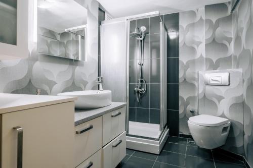 La salle de bains est pourvue d'une douche, d'un lavabo et de toilettes. dans l'établissement Sleek and Central, à Istanbul