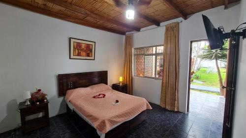a bedroom with a bed and a large window at Hospedaje El Cascabel in Sunampe