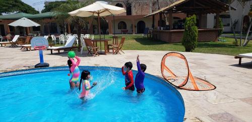 a group of children playing in a swimming pool at Hospedaje El Cascabel in Sunampe