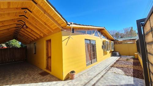 una casa amarilla con una puerta y una valla en Casa Los Andes en Los Andes