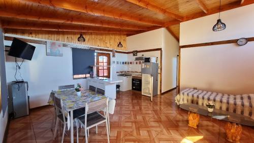 een woonkamer met een tafel en een keuken bij Casa Los Andes in Los Andes