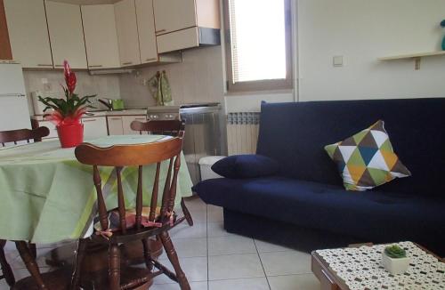 a living room with a blue couch and a table at Apartment Eni in Rovinj
