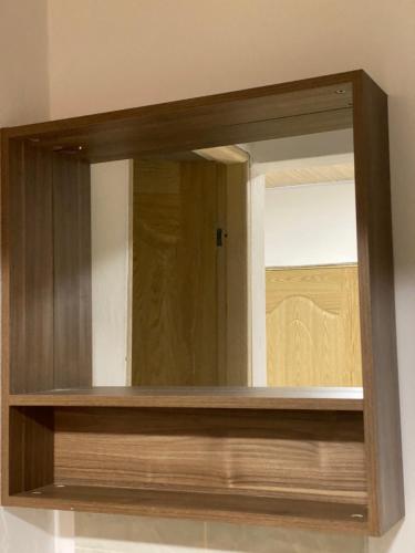 a mirror with a wooden frame on a wall at Oak Tree house in Guatapé