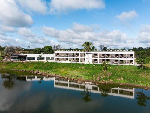 ein großes weißes Gebäude neben einem Wasserkörper in der Unterkunft Hotel Vista Lago 