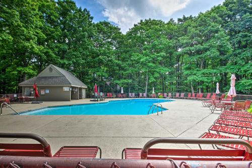 a swimming pool with red chairs and a building at Wintergreen Resort Condo with Deck, 0 3 Mi to Slopes in Lyndhurst