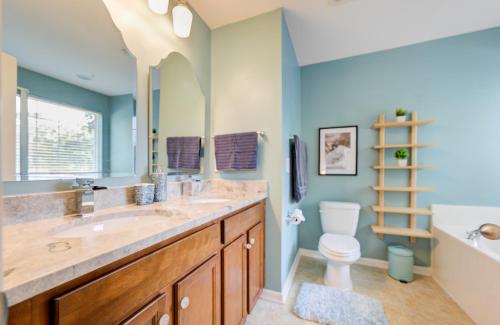 La salle de bains est pourvue d'un lavabo, de toilettes et d'un miroir. dans l'établissement Mulberry home with pond view, à Charleston