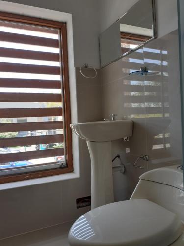 a bathroom with a sink and a toilet and a window at La Preferida in Lima