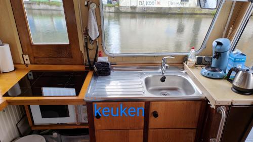een kleine keuken met een wastafel en een raam bij mooi leiden in Leiden