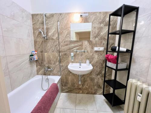 La salle de bains est pourvue d'une baignoire blanche et d'un lavabo. dans l'établissement Beautiful & peaceful apartment with cute balcony, à Prague