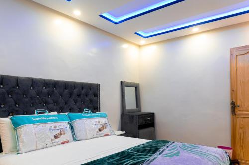1 dormitorio con 1 cama con techo azul en ADAM APPARTEMENTS en Dakhla