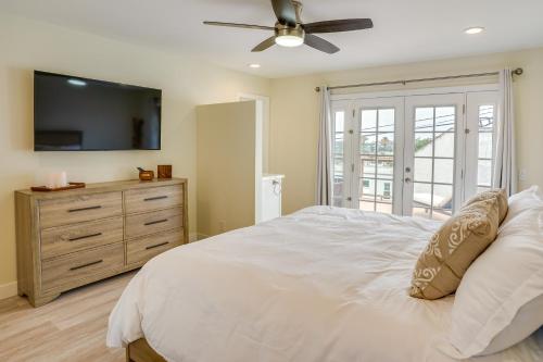 a bedroom with a bed with a ceiling fan and a dresser at Ocean-View Oasis Steps to Dana Point Beaches! in Dana Point
