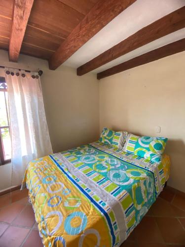 a bedroom with a bed with a colorful blanket at Oak Tree house in Guatapé